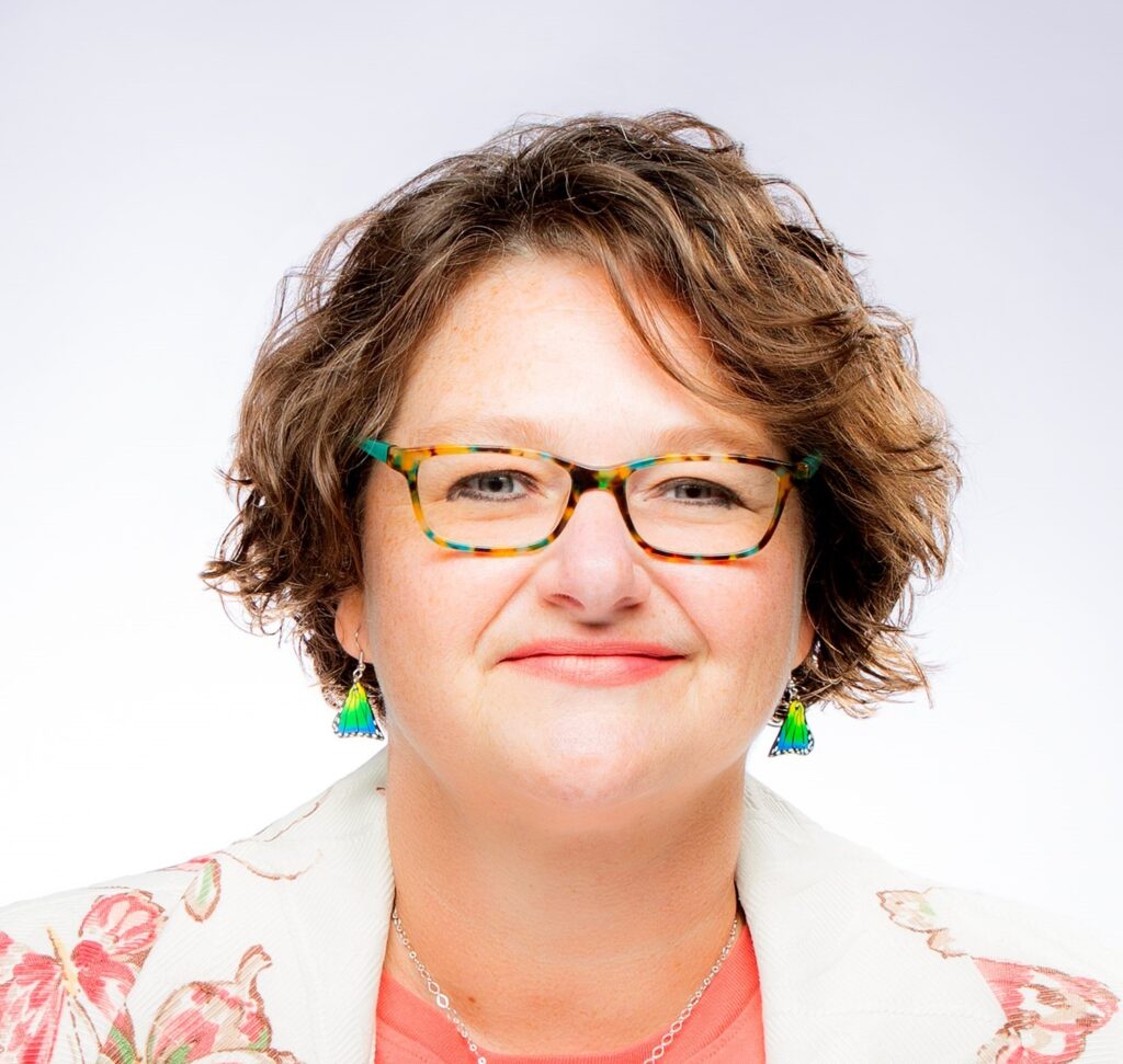 white woman with short brown hair and glasses smiling